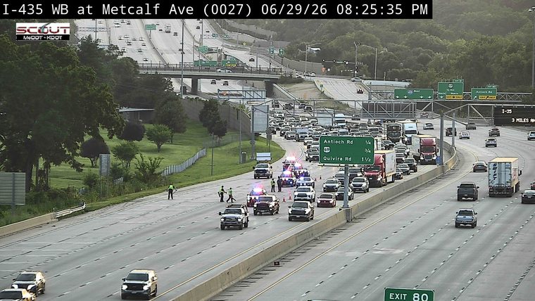 Multiple police cars with lights on in the left lanes