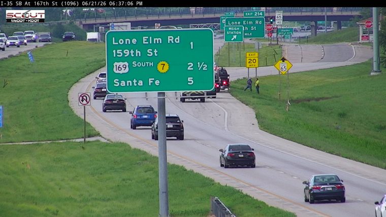 Two workers and a tow truck on the right shoulder