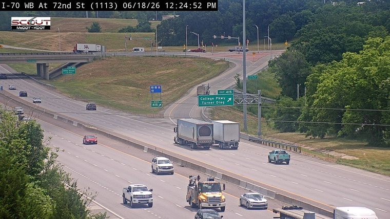 A tow truck is stopped on the shoulder with its hazard lights on.