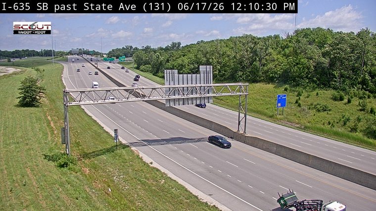 Debris from a trailer is scattered on the right shoulder of the highway.