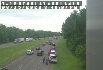 Emergency vehicles and personnel on the side of the highway.