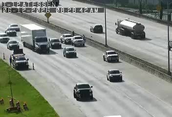 A tow truck and other vehicles are stopped on the side of the highway.