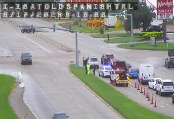 Emergency responders and vehicles are present on the roadside, indicating an incident.