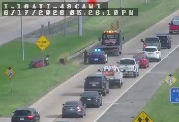 Vehicle overturned on the side of the road with a tow truck present.