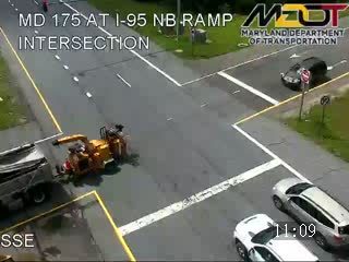 Road work crew with equipment on the roadway at an intersection.