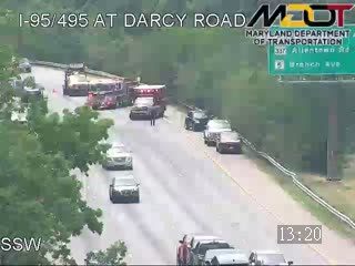 Multiple emergency vehicles and vehicles stopped on the highway, indicating an incident.