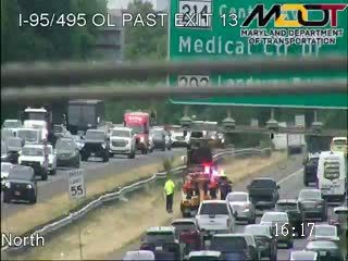 Multiple emergency vehicles and personnel on the right shoulder