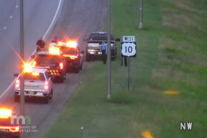 Police vehicles with lights on at the roadside, personnel present.