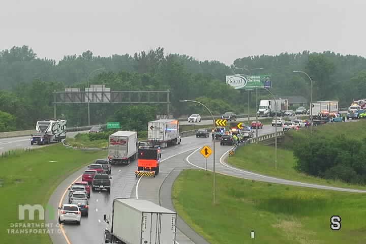 Multiple police cars and emergency personnel on the right shoulder