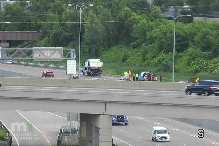 Multiple vehicles and people on the right shoulder