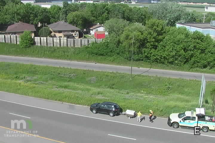 Two people in safety vests near a disabled vehicle and a response truck.