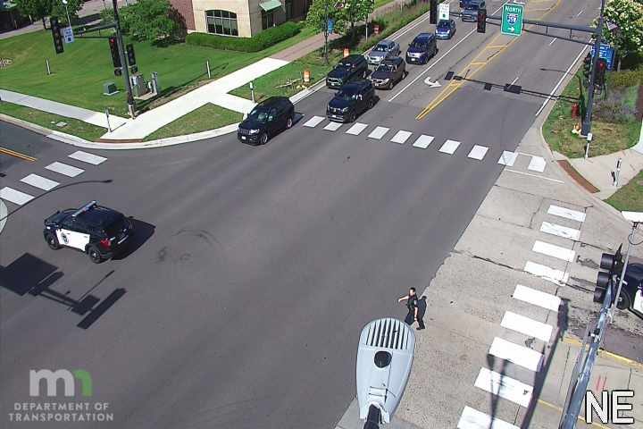 Police car with lights on the left side of the intersection