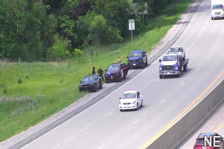 Police officers and vehicles on the roadside with a civilian vehicle.