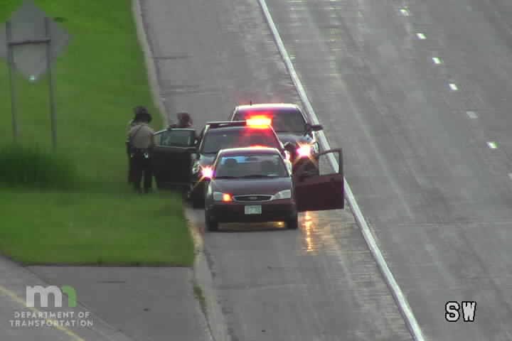 Police car with red and blue lights on the shoulder