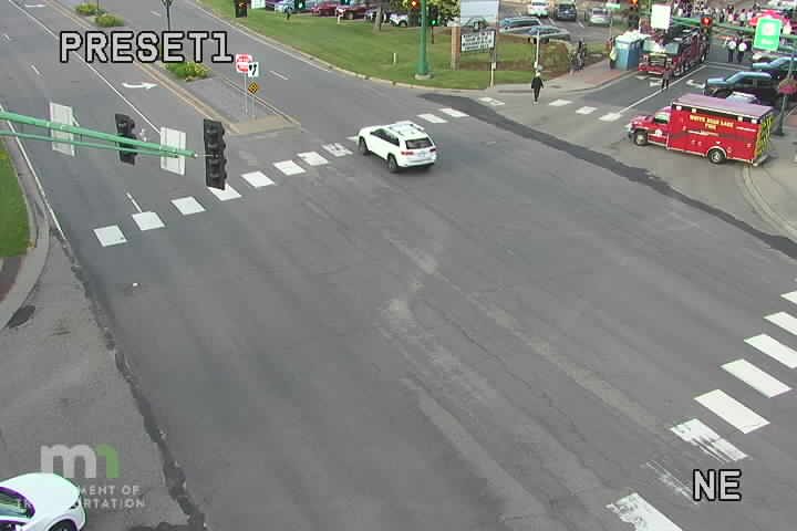 Red ambulance with flashing lights on the right side of the intersection