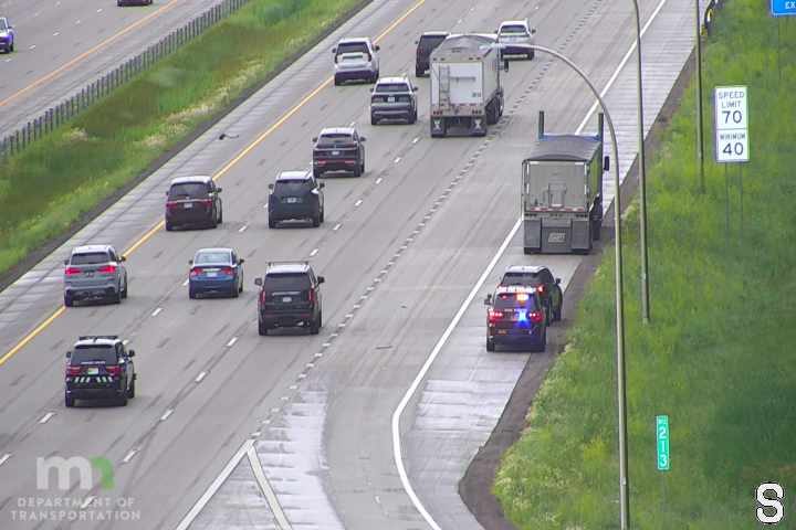Police car with flashing lights on the shoulder of the highway.
