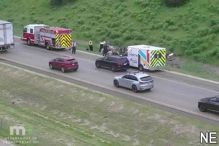Fire truck and ambulance with responders near a damaged vehicle in the right lane