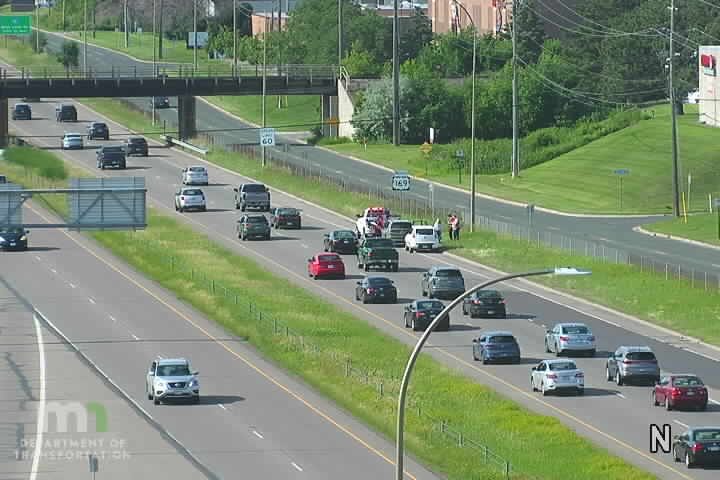 Emergency responders and vehicles are present on the shoulder of the highway.