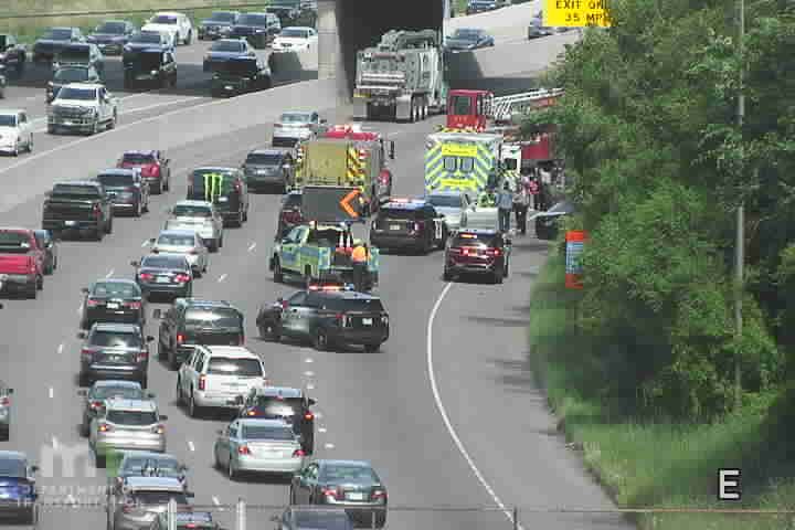 Emergency responders and vehicles are present on the highway, causing traffic delays.