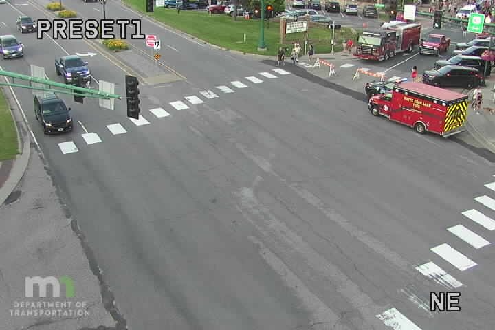 Red and yellow fire truck with emergency lights on the right side of the roadway