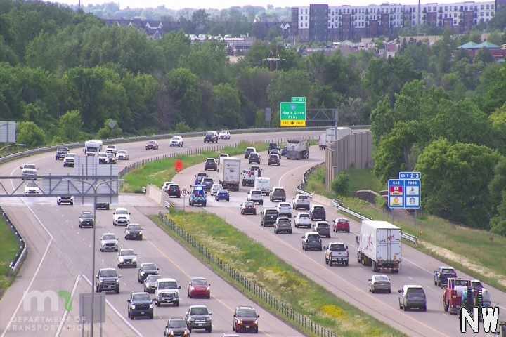 Police car with lights on blocking traffic on highway.