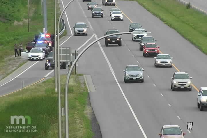 Police car with red and blue lights on the shoulder