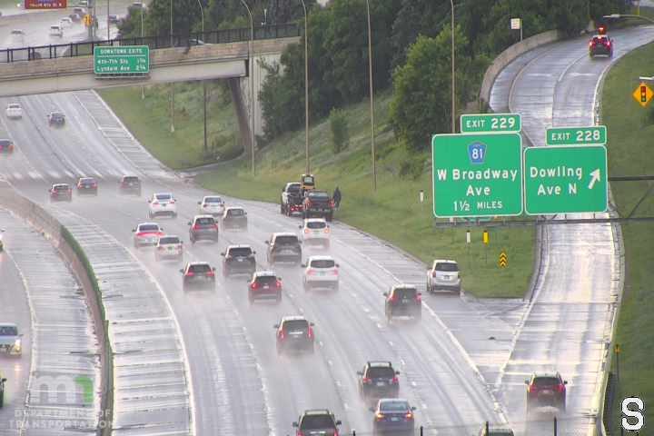 Tow truck and personnel on the side of the wet highway.