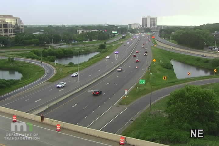 Emergency vehicles with flashing lights are stopped on the highway, indicating an incident.