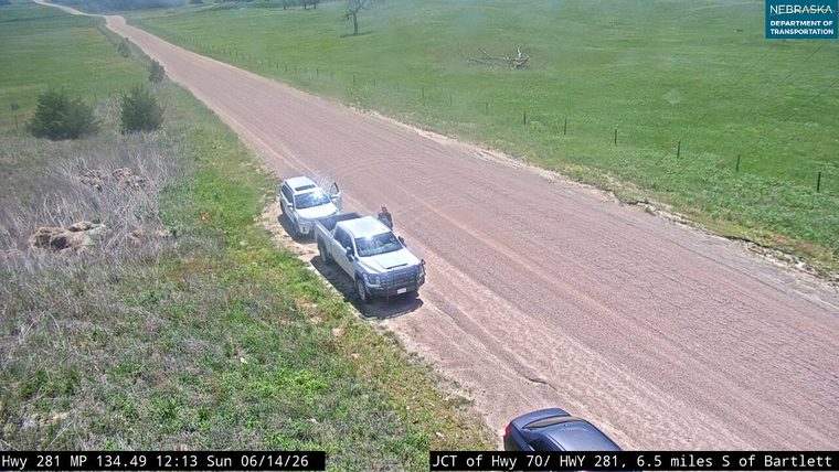 Two vehicles stopped on the shoulder, one with an open door, person visible.