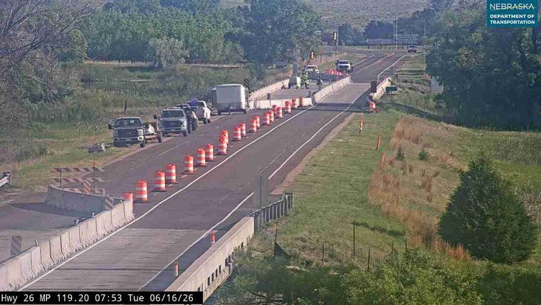 Traffic cones and barriers indicate road work with responders present.