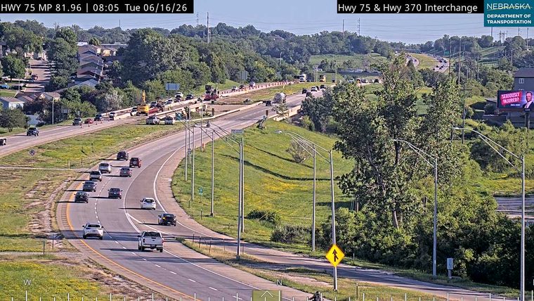 Emergency responders and construction equipment are present on the highway, causing traffic delays.