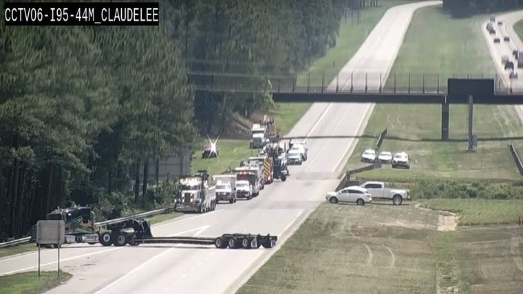 Multiple emergency vehicles and tow trucks lined up on the right shoulder and partially in the right lane
