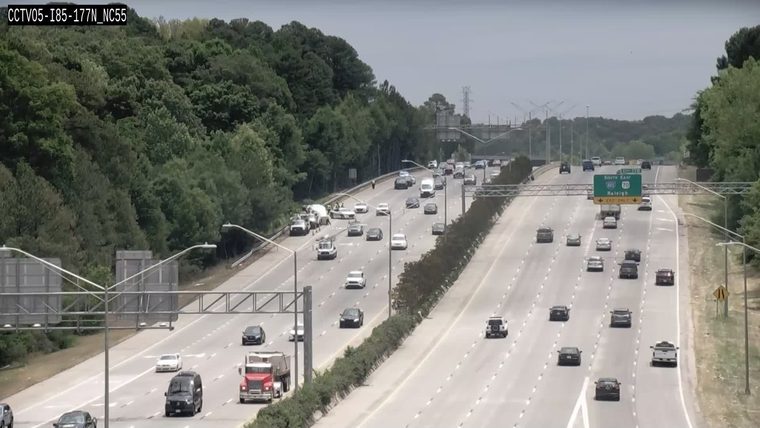 Emergency responders and vehicles are present on the shoulder of the highway.