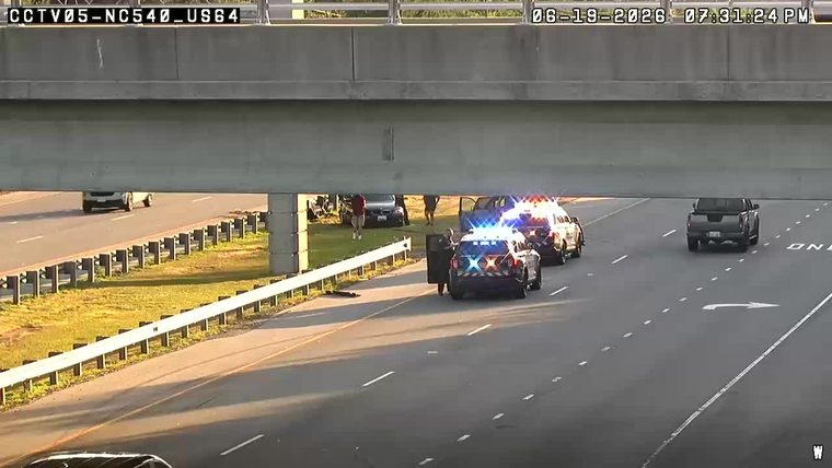 Police cars with flashing lights on the right shoulder