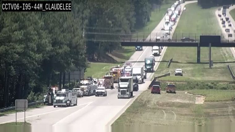 Multiple emergency vehicles and tow trucks on the right shoulder