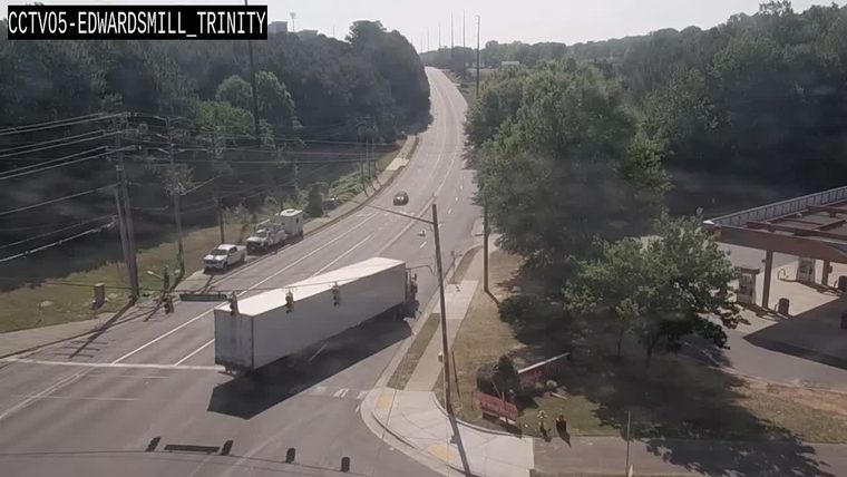 Emergency responders are present near a gas station with traffic control measures.