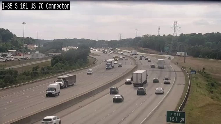 Emergency vehicles and personnel are visible on the shoulder of the highway.