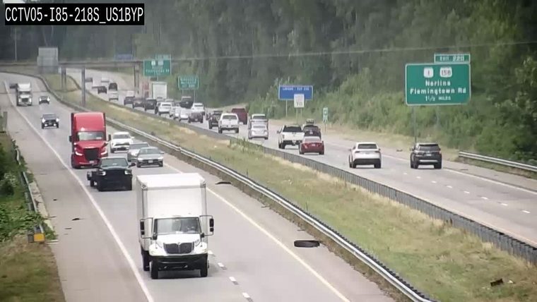 Tire debris is scattered across multiple lanes of the highway.