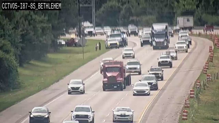 Emergency responders and vehicles are present on the roadside, directing traffic.