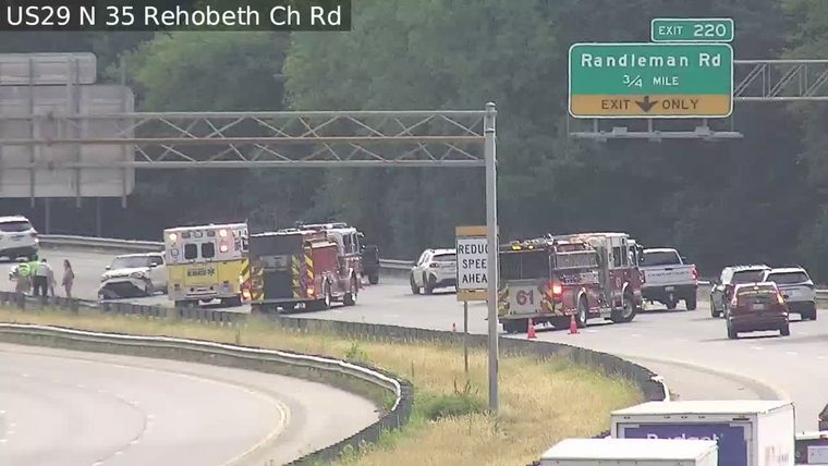 Emergency responders and vehicles at a roadside incident with a damaged car.