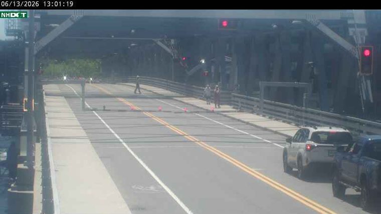 Several people and traffic cones are on the roadway, possibly indicating a responder scene.