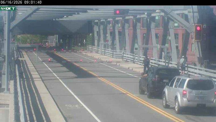 Traffic cones and people on bridge suggest a responder incident.