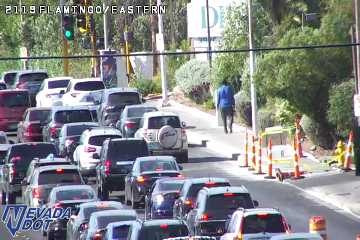 Construction cones and a small trailer on the right shoulder