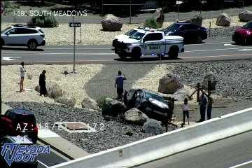Overturned vehicle in the median with several people around it