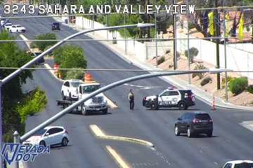 Police car and tow truck with a vehicle on it in the roadway
