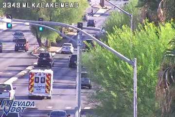 Ambulance with red and blue lights on in the left lane