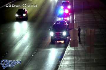 Police car with red and blue lights on the right shoulder