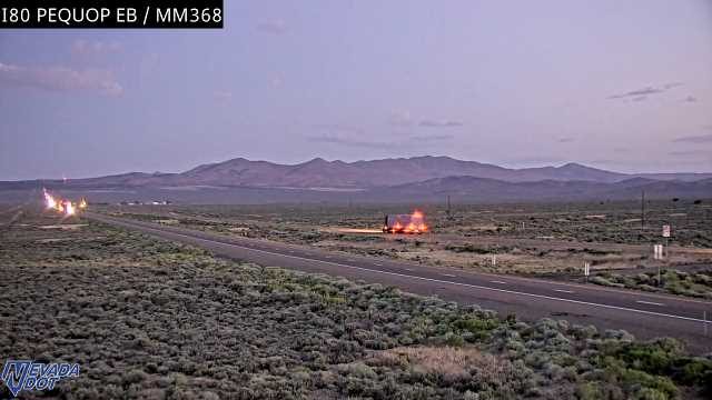 Semi-truck on fire off the right side of the highway