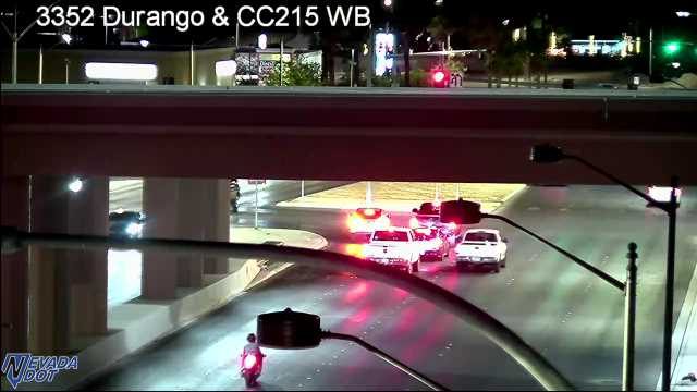 Two police vehicles with red and blue lights activated in the intersection