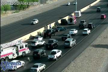 Fire truck and emergency responders at a multi-vehicle crash scene near the left median wall